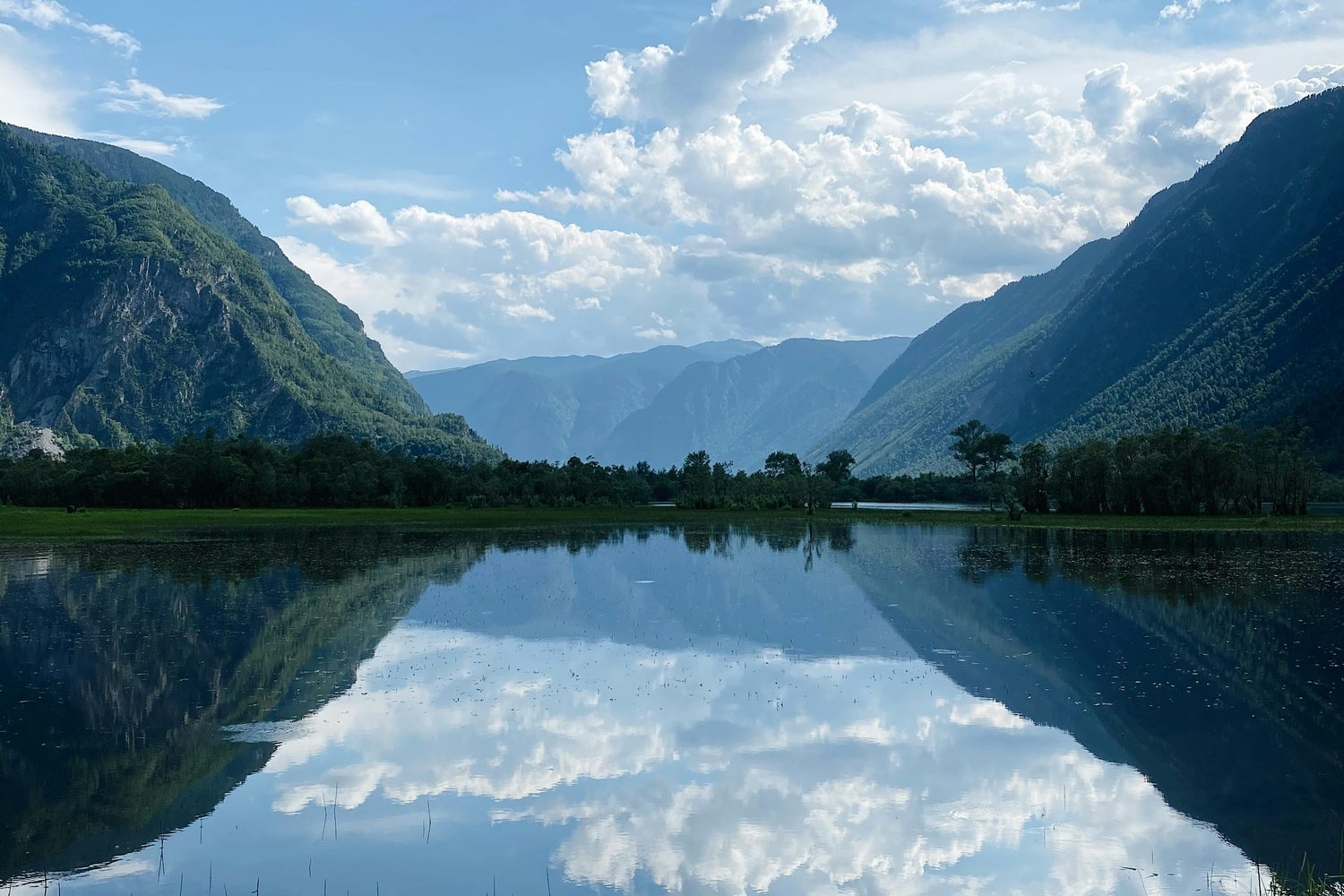 A still mountain lake mirroring the sky